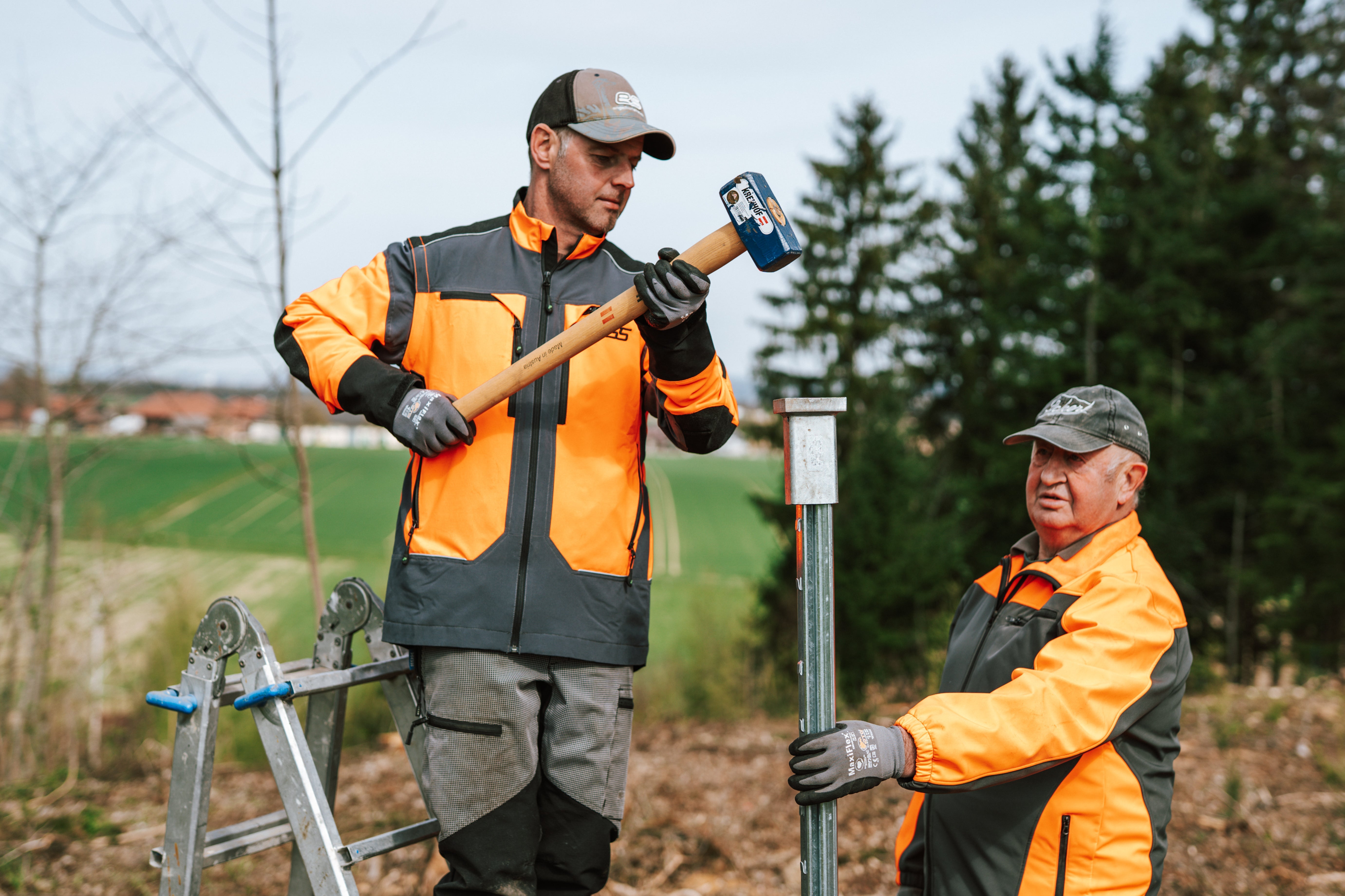 Pfahl wird mit Hilfe der Einschlaghilfe in den Waldboden geschlagen